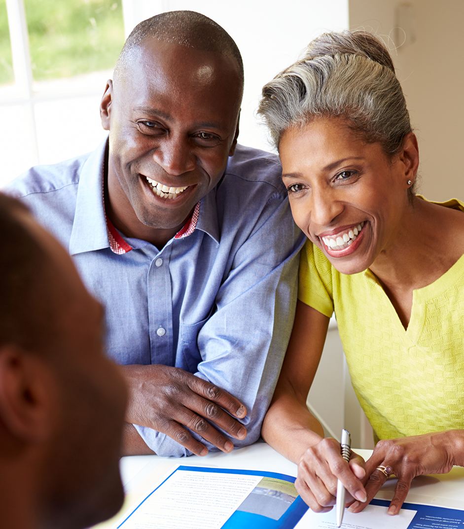 A couple going through paperwork with their advisor